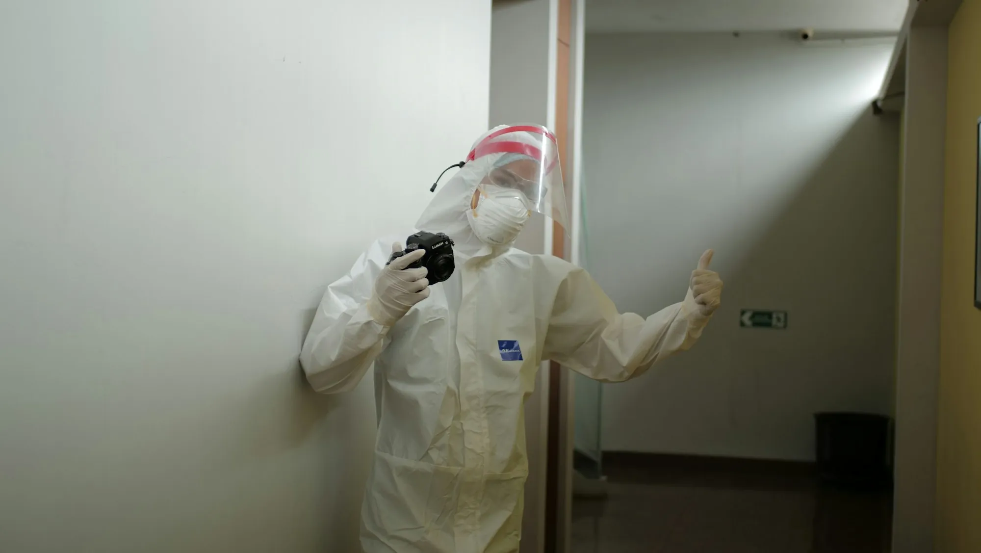 Worker in a white protective suit and respirator inside a sealed room